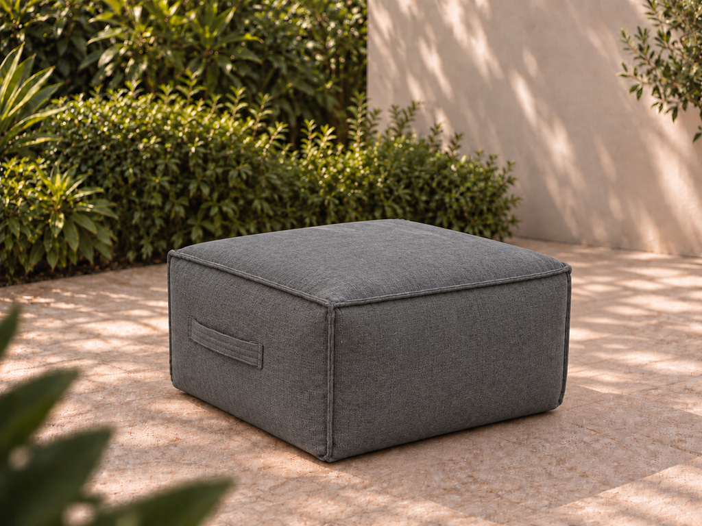 Cove Ottoman in Charcoal Sunbrella fabric on a garden terrace
