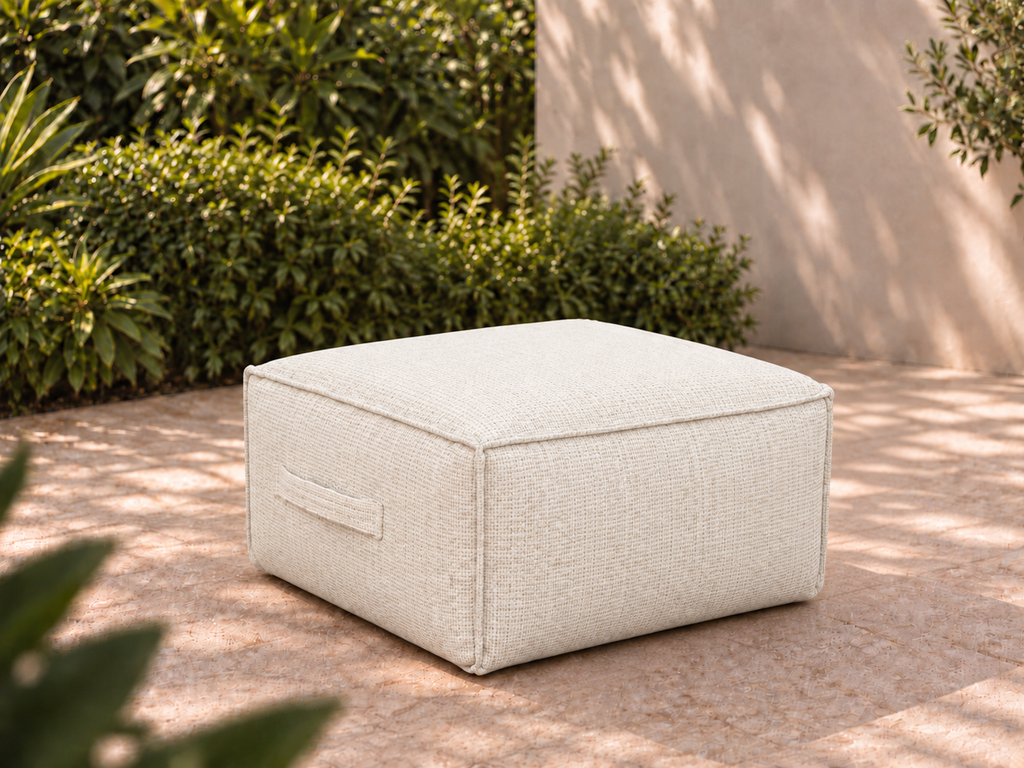 Cove Ottoman in Nurture White Sunbrella fabric on a garden terrace