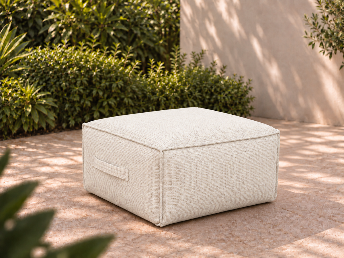 Cove Ottoman in Nurture White Sunbrella fabric on a garden terrace