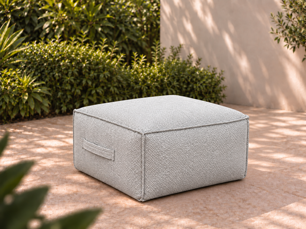 Cove Ottoman in Nurture Pebble Sunbrella fabric on a garden terrace